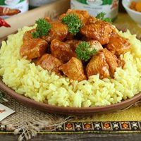 Курица карри с жёлтым рисом на глиняной тарелке