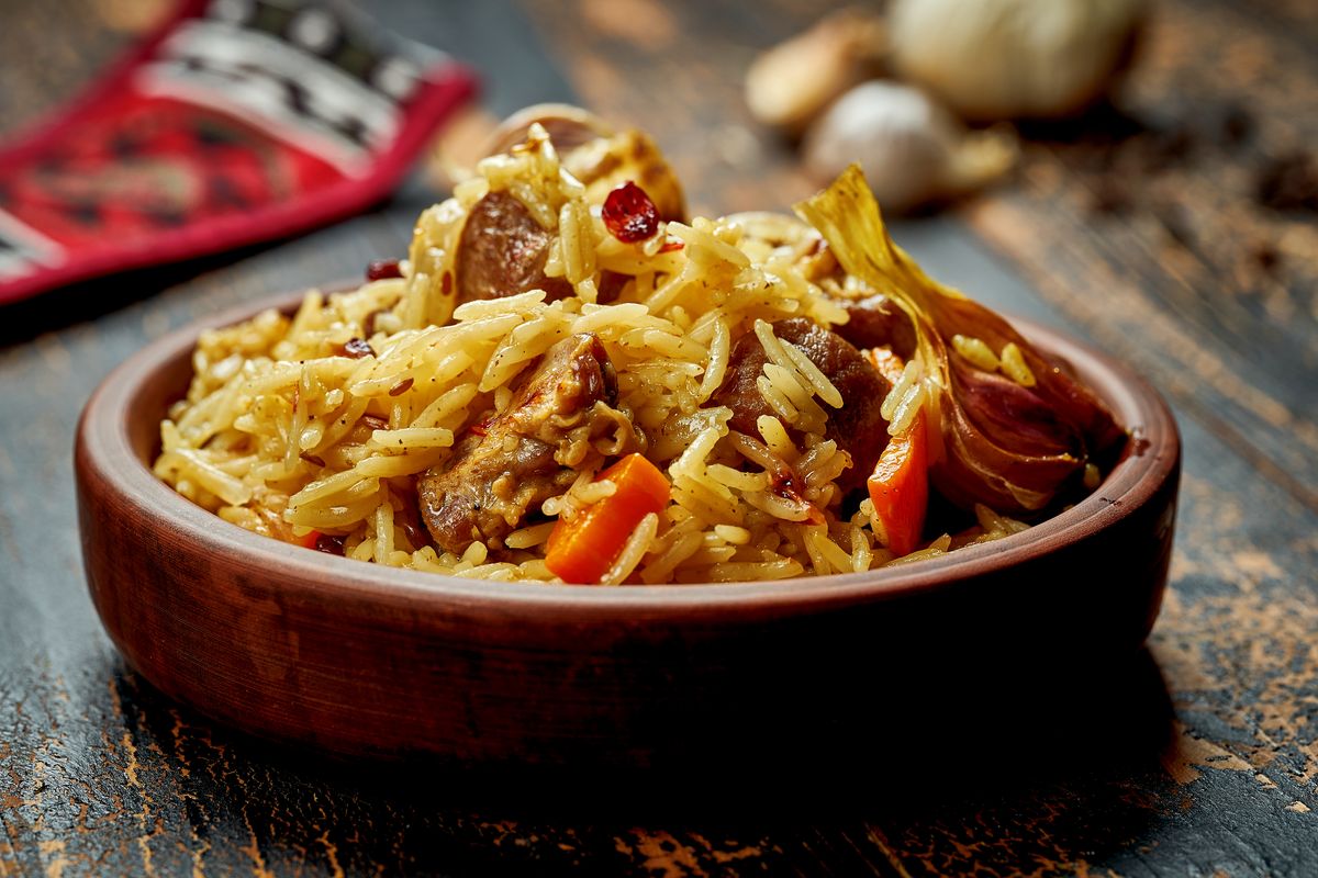 Рассыпчатый плов с мясом, морковью соломкой и ягодами барбариса в глиняной касушке