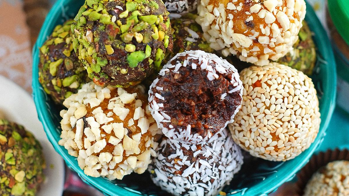 Цукерки з кураги та чорносливу в кунжуті, кокосі й фісташках у бірюзовій піалі