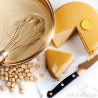Растопленный шоколад Gold в миске, каллеты и торт в янтарной глазури