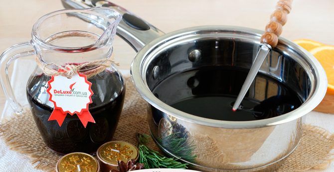 Вино с кружками апельсина нагревается в ковше на плите